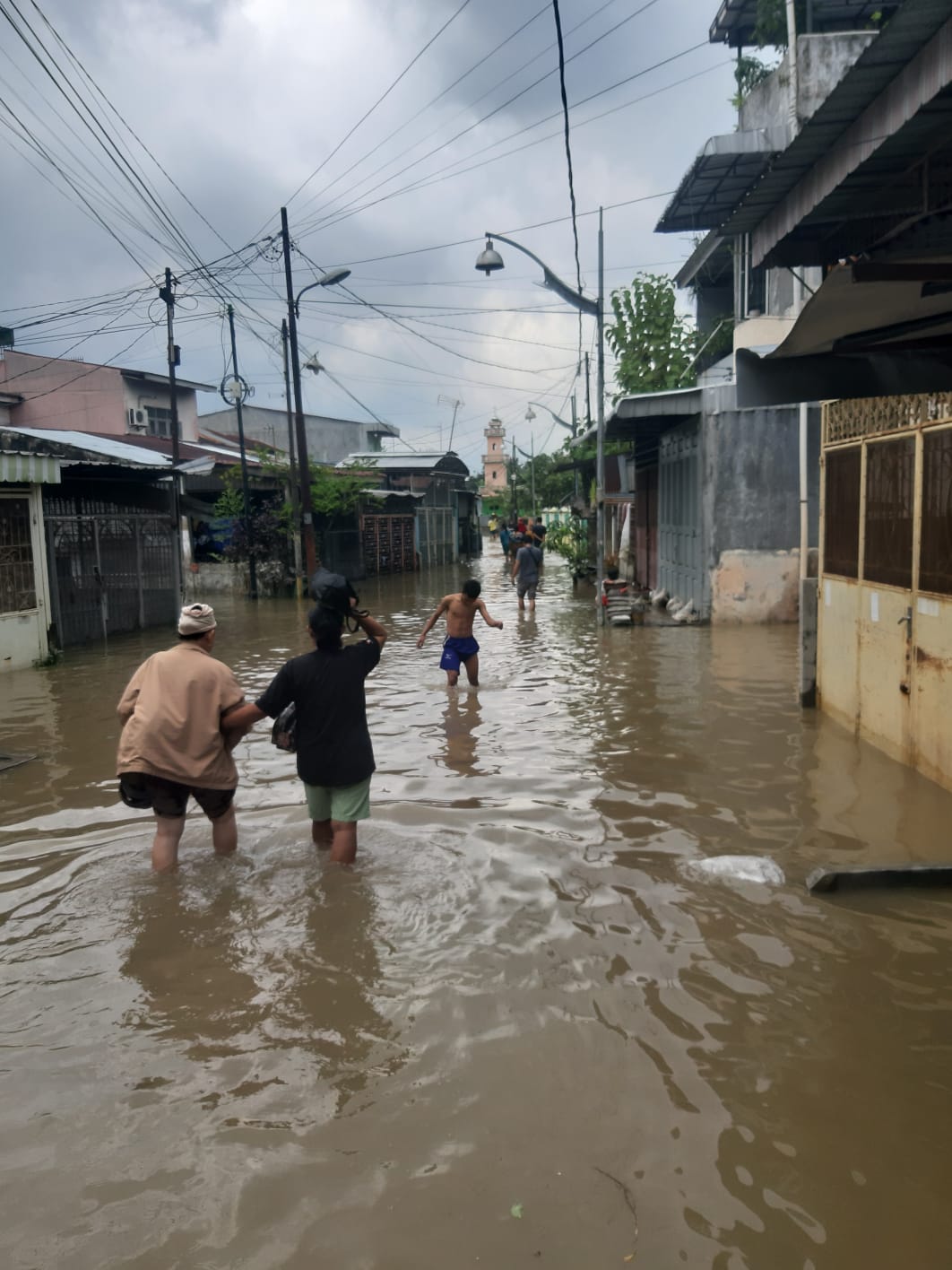 Warga Kelurahan Kampung Baru Berkumpul di Pinggir Jalan Menunggu Air Surut